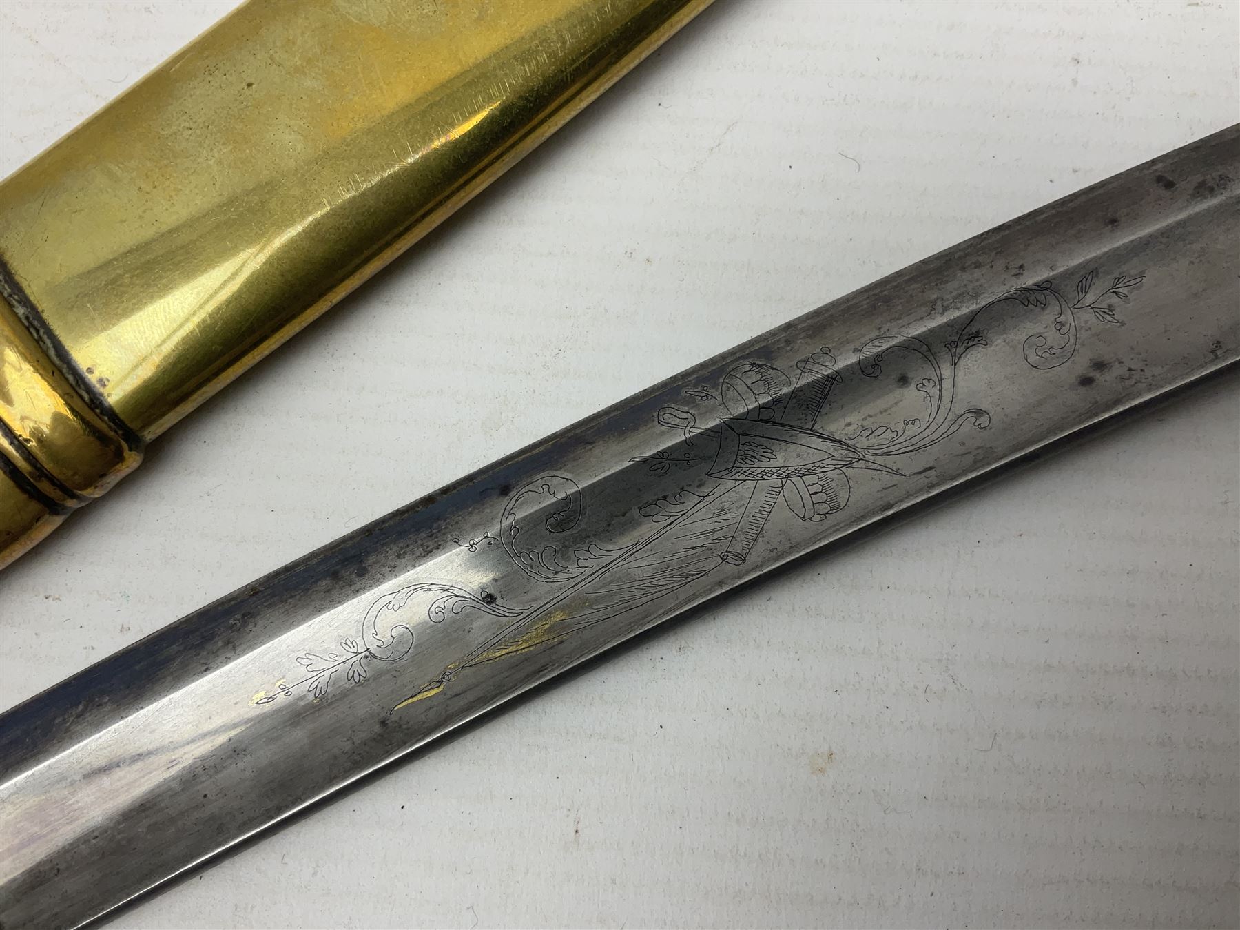 German Saxon 1st Empire Light Cavalry officer's sword c1820s, the 79cm clipped curving blade engraved with the crest of Hanover and various battle trophies with traces of blueing and gilding, brass hilt with knucklebow, foliate square langets, ornate downswept quillon, wire-bound fish skin grip with lion's head pommel; in brass scabbard with two suspension rings L95cm overall