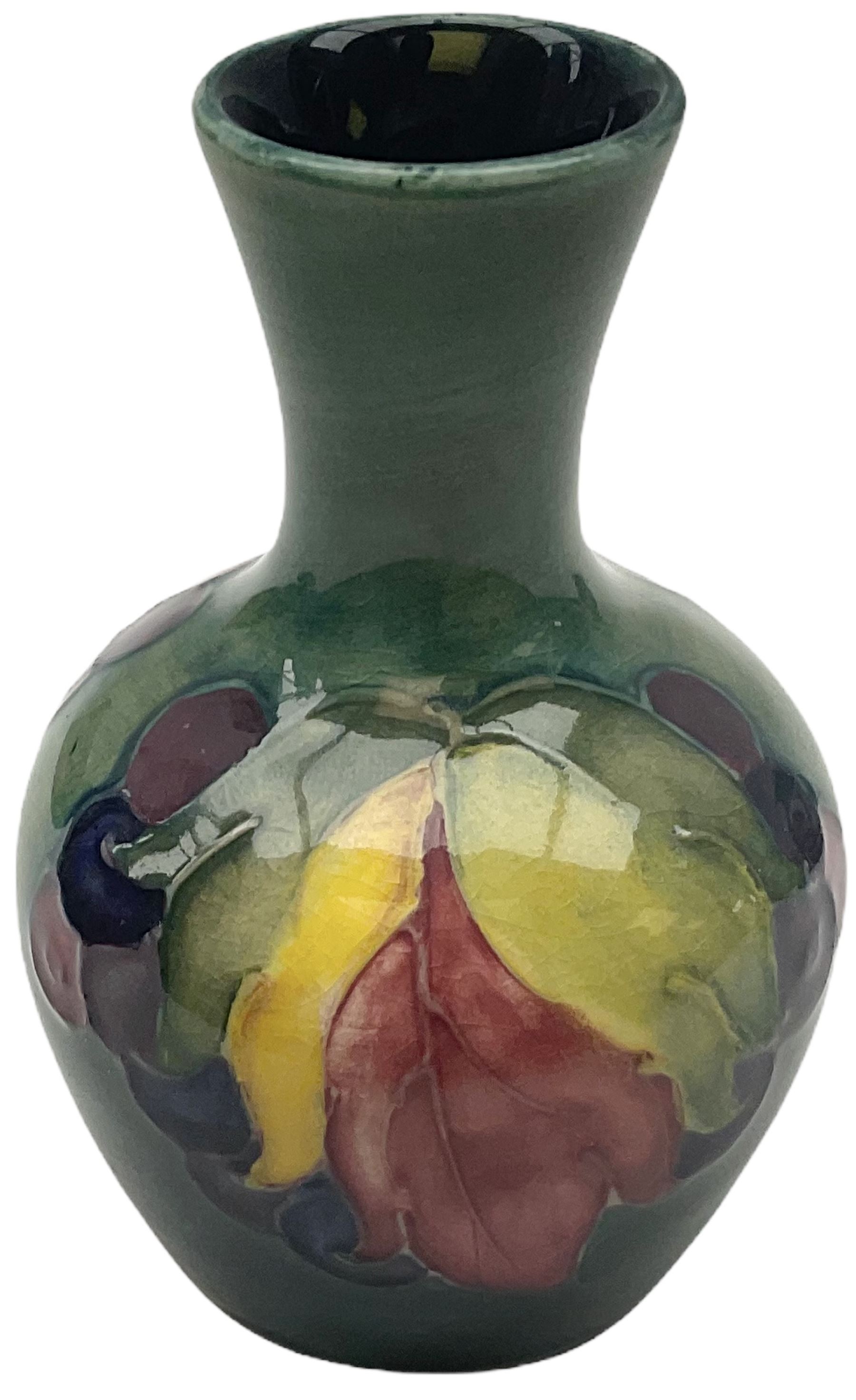 Moorcroft vase, decorated in the Leaf and Berries pattern upon a tonal green ground, together with a further Moorcroft vase, of squat baluster form, decorated in the Iris pattern upon a tonal green ground, each with impressed marks beneath, each H9cm. 