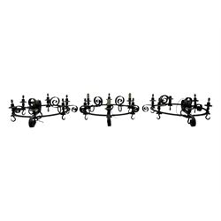 Set of three mid-20th century wrought iron six-light chandeliers, each with a circular frame with scrolled arms, faux candle sleeves and hook terminals