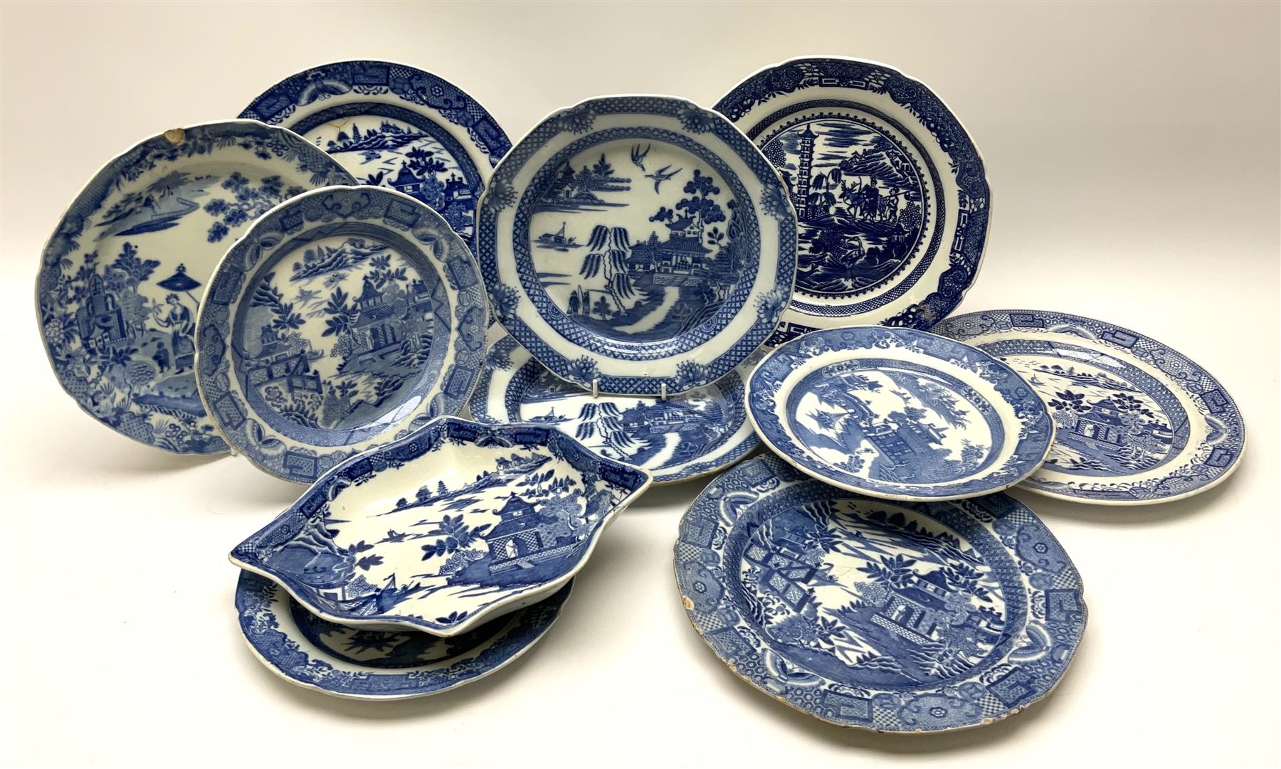 A group of 19th century blue and white transfer printed pottery, various makers and patterns, to include Minton Queen of Sheba pattern plate, Joshua Heath Reindeer pattern plate with towering pagoda, and seal in the foreground, a number of plates decorated in the Chinoiserie Bridgeless pattern, two Mandarin type pattern plates, possibly Spode, etc. 