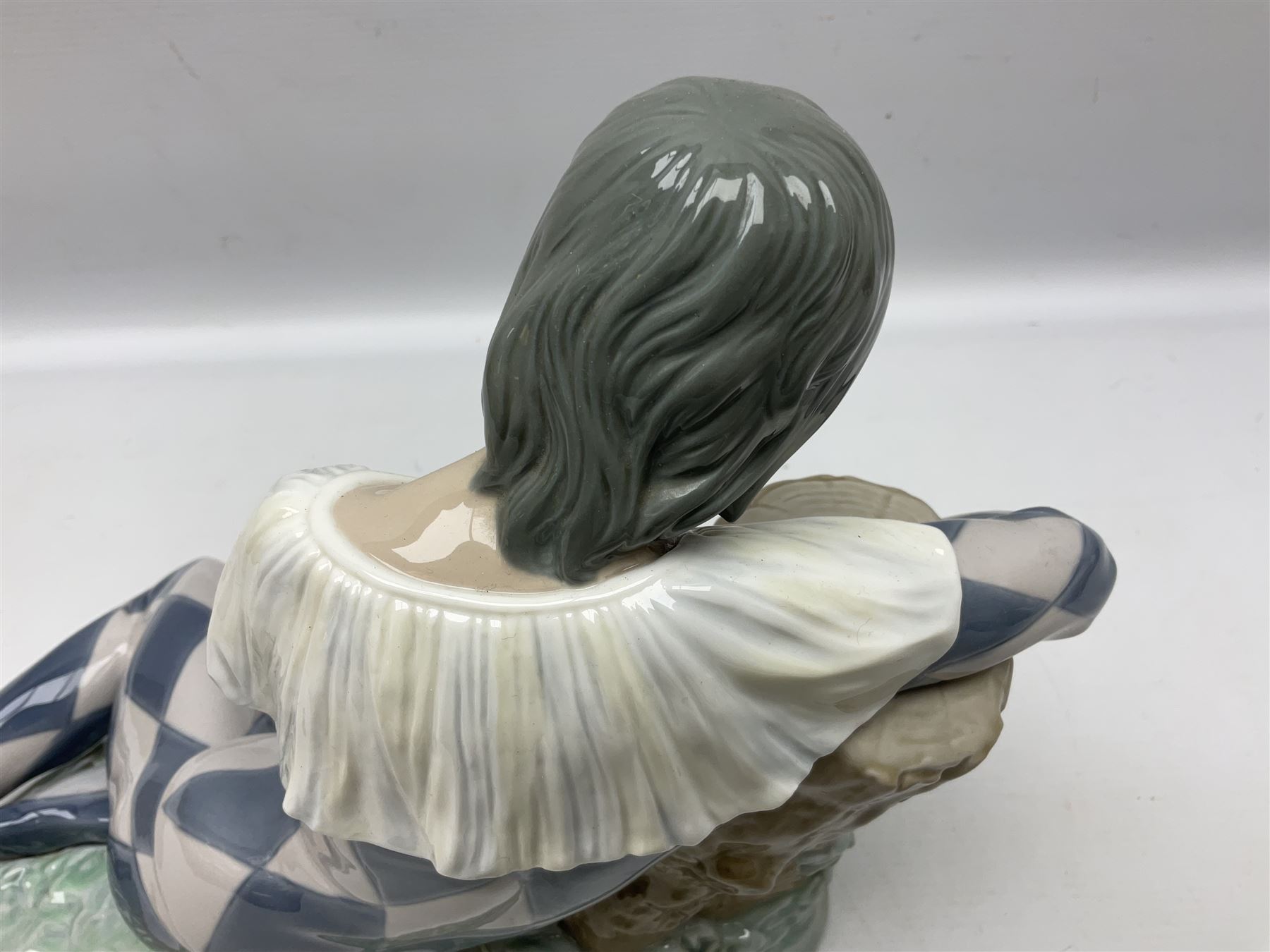 Lladro figure, Harlequin Reclining, modelled as a recumbent harlequin, no 5128, Sculpted by Salvador Furio, year issued 1982, year retired 1987, H28cm 