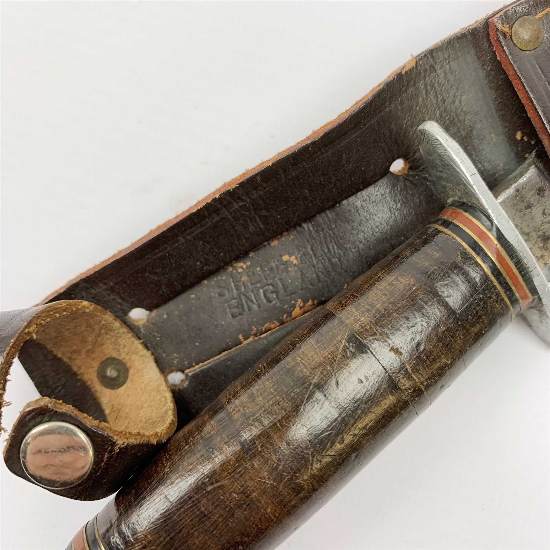 American WW2 type fighting knife with 15cm steel double edged blade, aluminium crosspiece and pommel and leather bound grip, in leather sheath marked Sheffield England L27cm overall; and another similar fighting knife with antler grip and no sheath (2)