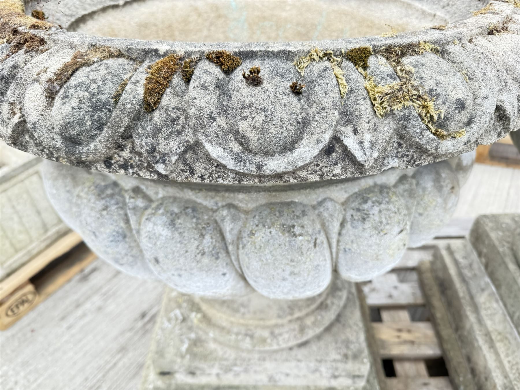 Pair of large weathered Country House Haddonstone garden urns, acanthus carved rim above gadrooned bowl, beaded detailing to the neck, raised on stepped double plinth base

