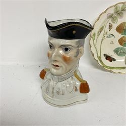 Chelsea style dish moulded as a large flower head with green stalk handle and two leaves with red anchor mark beneath, 19th century Staffordshire character jug modelled as the Duke of Wellington in military uniform, and a late Chamberlain plate