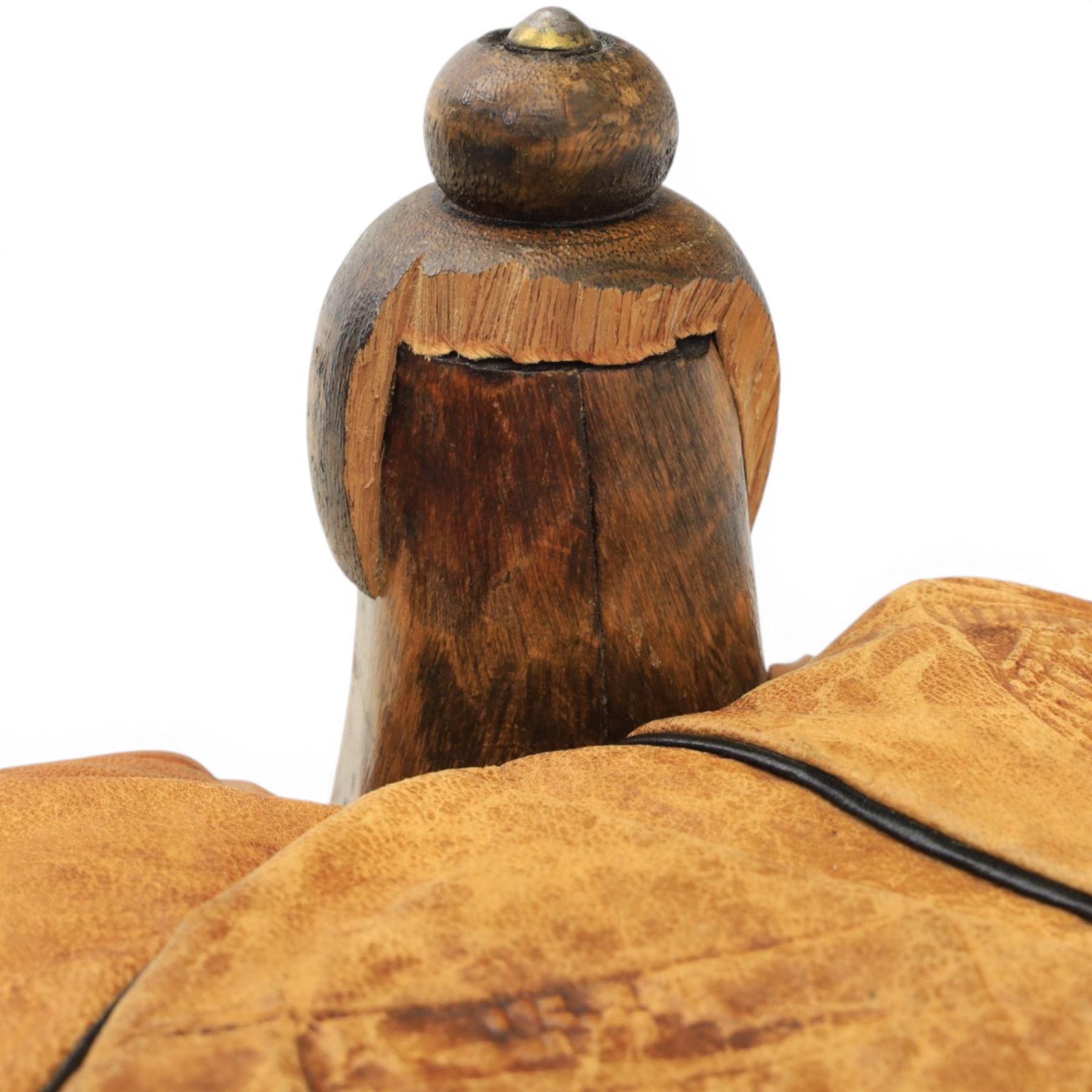 20th century Camel stool, with wooden turned finials, above a tooled leather seat, curved supports with brass applications 