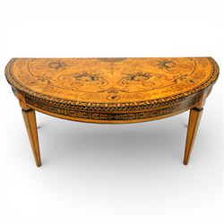 20th-Century Louis XVI-Style satinwood and penwork circular table or pair of console tables, the circular quarter-veneered top decorated in penwork with a central classical mask head motif within scrolling foliate and anthemion ornament on a contrasting black ground, above a conforming frieze decorated with Greek key-type scrolls. Raised on square tapering legs, each with an upper block panel decorated with compass-star motifs.