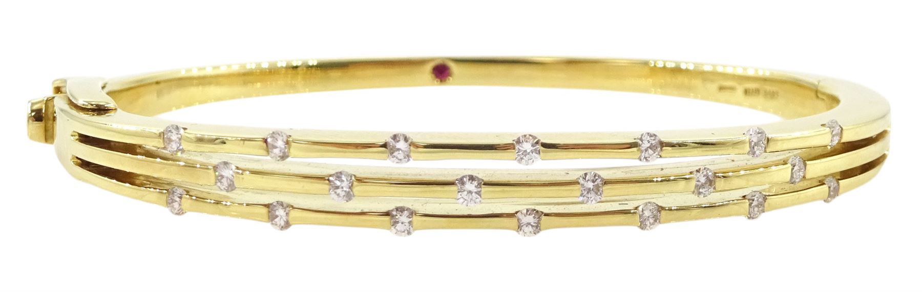 Roberto Coin 'Parisienne' 18ct gold three row round brilliant cut diamond bangle, with a signature round cut ruby to the underside and ruby set clasp, Birmingham 2006, boxed