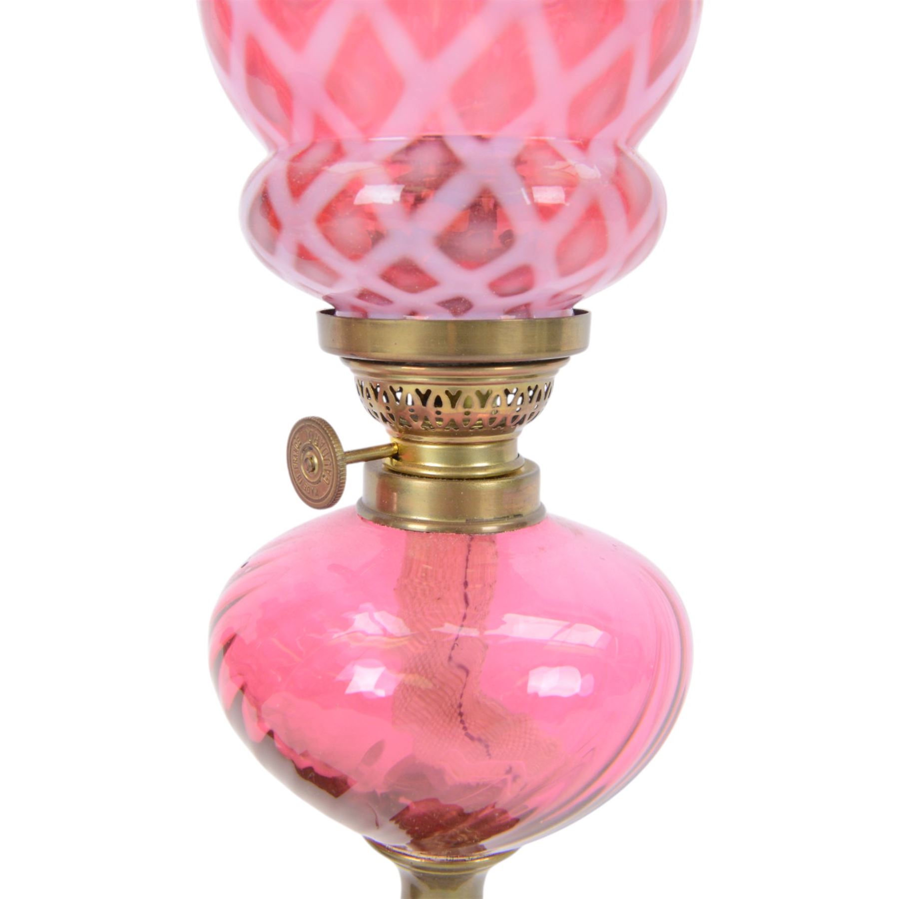 Pair of cranberry glass and brass oil lamps, with frilled graduated cranberry glass shade, cranberry reservoir with brass Gaudard burner, upon knopped column  with stepped square base, H46cm