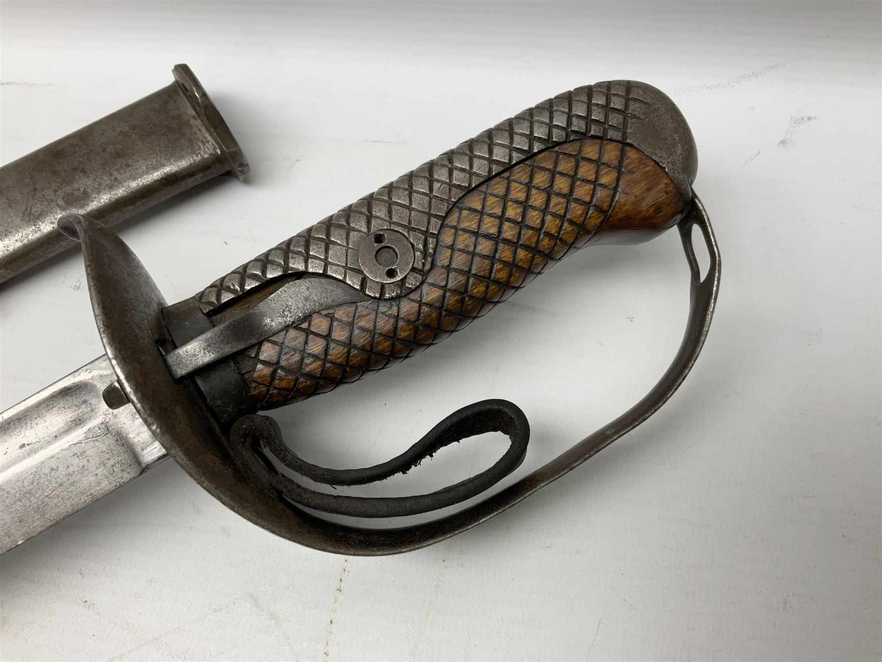 WW2 Japanese Model 1899 Type 32 'Ko' pattern cavalry sword, with 82.5cm single edged, slightly curved blade with narrow fuller, numbered 33825 to the ricasso; steel hilt with chequered backstrap and grip ears with wooden chequered grip and leather finger loop; locking action; in steel scabbard with single hanging ring L99.5cm overall