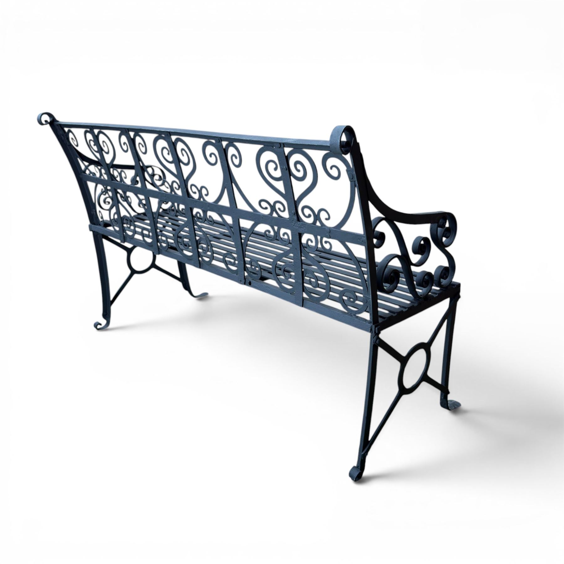 Regency period wrought iron garden bench, hand forged in wrought iron and finished in matt black paint, decorated with intricate scrollwork and featuring circular geometric ends, strapwork seat