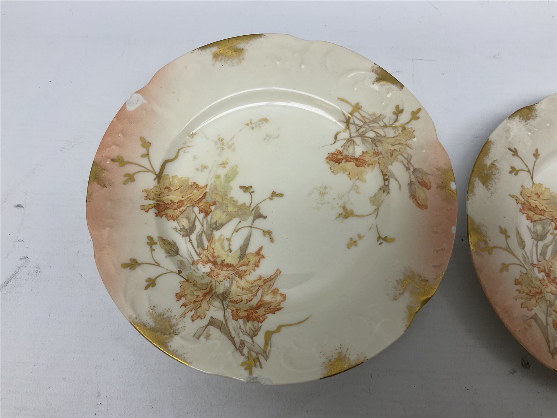 Early 20th century Limoges part tea service, decorated with floral sprays and gilt on merging peach and white ground, comprising six teacups, twelve side plates, six smaller plates, milk jug, open sucrier, slop bowl and two cake plates, many marked R Delinieres Limoges D&C France to base