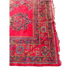 Early 20th century Western Anatolia Turkish Oushak crimson ground carpet, the field decorated with rows of Herati and Palmette medallions, the main border decorated with stylised flower head motifs within guard stripes