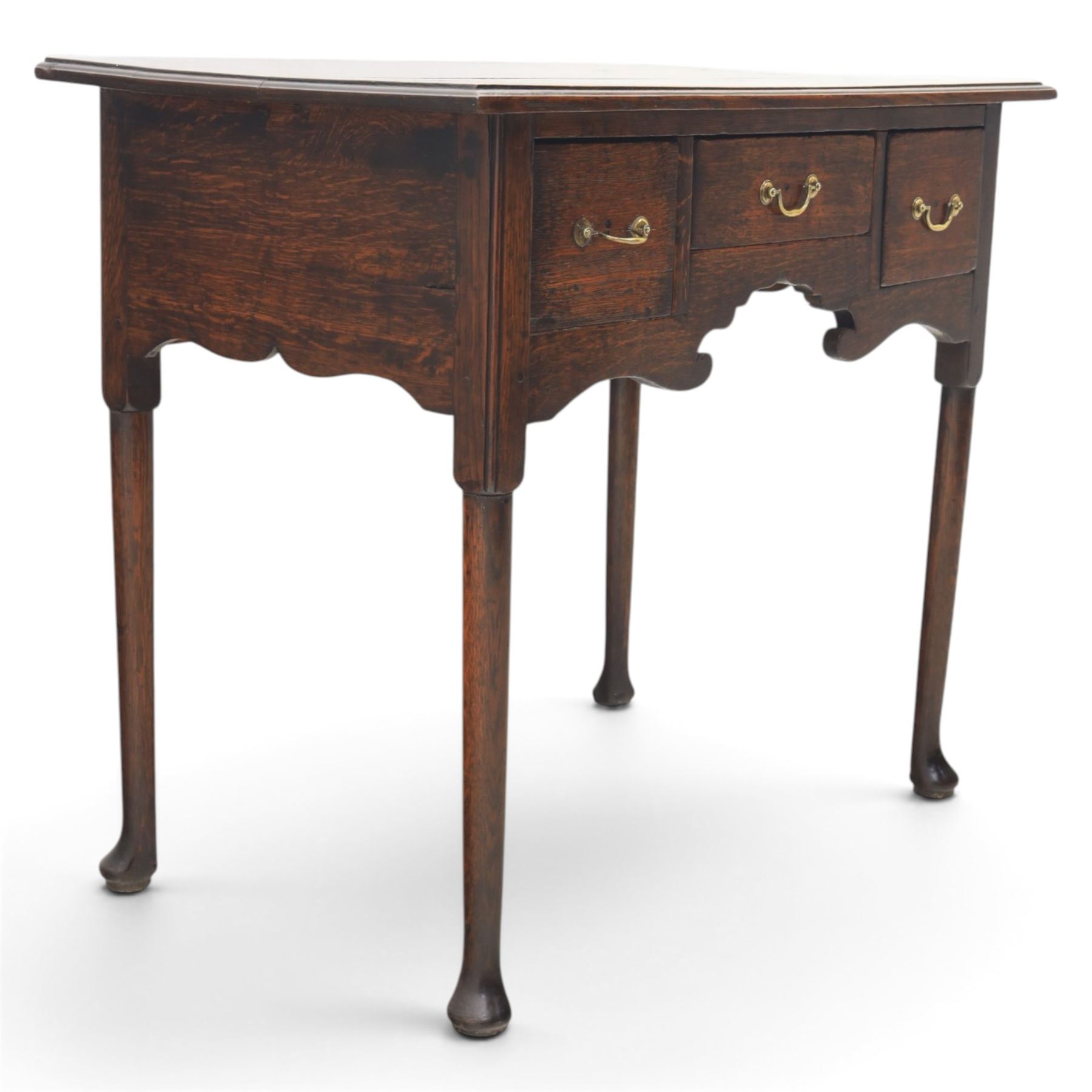 18th century oak lowboy, rectangular plank top with moulded edge, above three assorted drawers with brass swan neck handles, shaped apron raised on pad feet