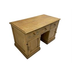 Large pine knee hole desk, rectangular moulded top over three drawers and two cupboards, panelled sides and back, on plinth base