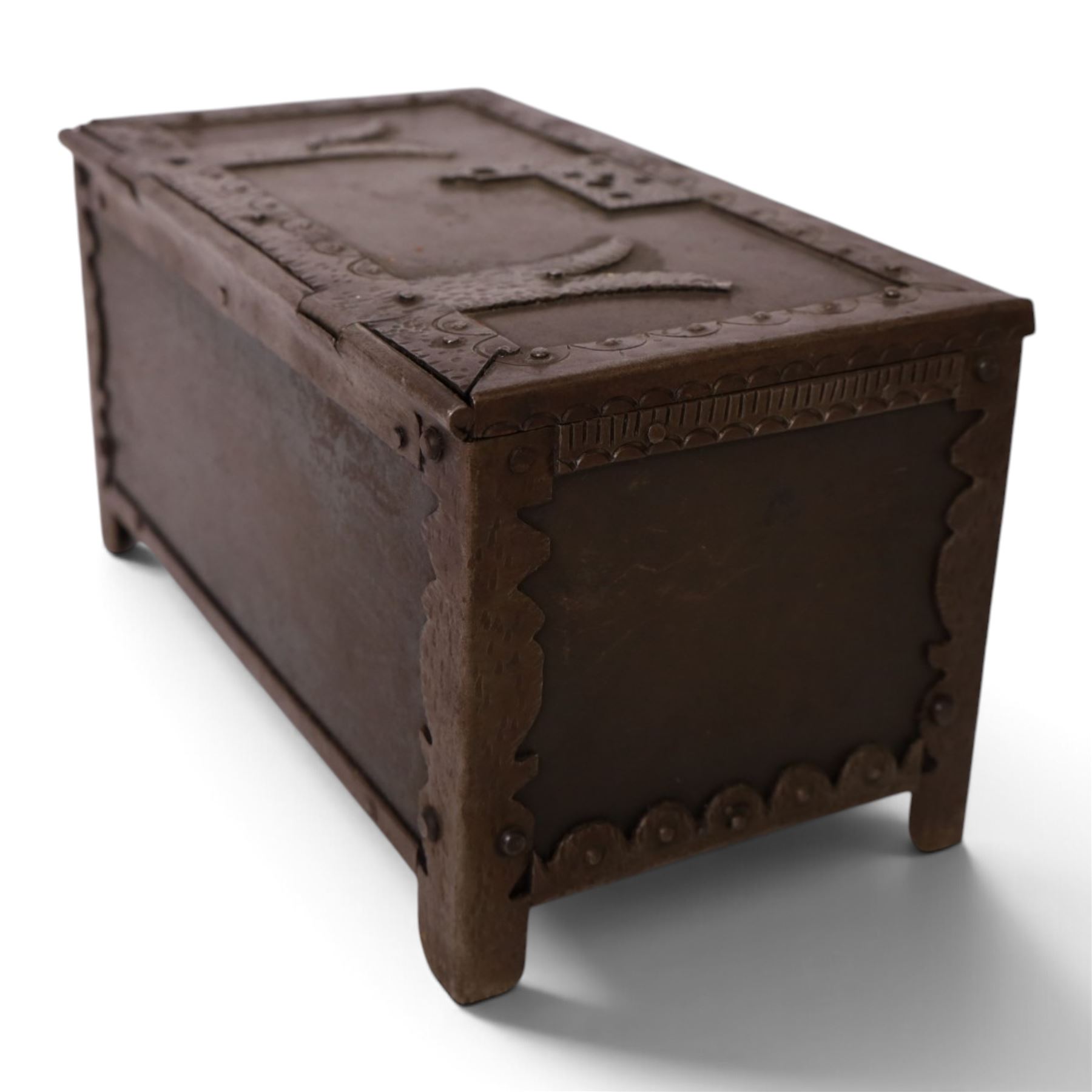Late 19th/early 20th century vernacular iron box, the hinged cover and sides with applied strapwork decoration, the cover with applied church motif, H11.5cm W22cm D12cm
