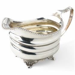 George III silver cream jug with gadrooned edge and leaf capped handle on shaped supports London 1817 Maker Robert Peppin and a small Victorian silver sauce boat with crimped rim Birmingham 1893 Maker Thomas Hayes (2)