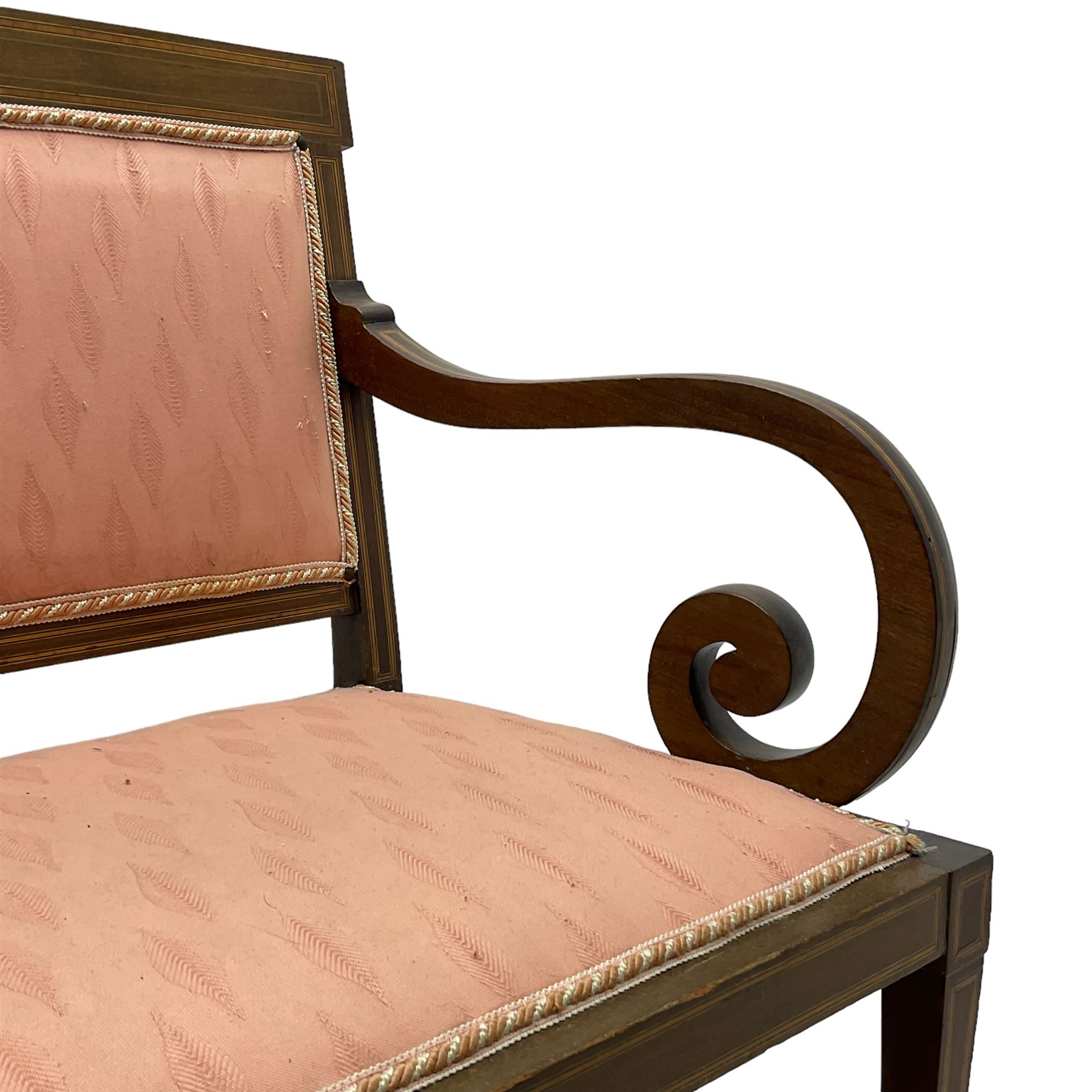 Edwardian inlaid mahogany two-seat settee or hall bench, the cresting rail inlaid with satinwood banding and boxwood stringing, central panel inlaid with scrolled leafy branches over pierced and carved lyre back, upholstered in peach fabric with repeating pattern, scrolled down sweeping arms, on square tapering supports with spade feet 