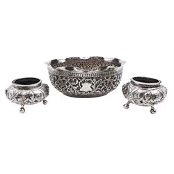 Indian silver dish, of oval form with shaped rim, chassed and embossed with leaves and C scrolls, H4.5cm W12.4cm D9.8cm together with a pair of Indian silver open salts depicting the Goddess Vasudhara, each upon three ball feet, H3.5cm, approximate weight 5.6 ozt (174 grams)