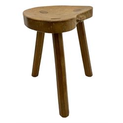 'Rabbitman' oak milking stool, dished kidney shaped top with three tapered octagonal supports, carved with rabbit signature to rim, by Peter Heap of Wetwang