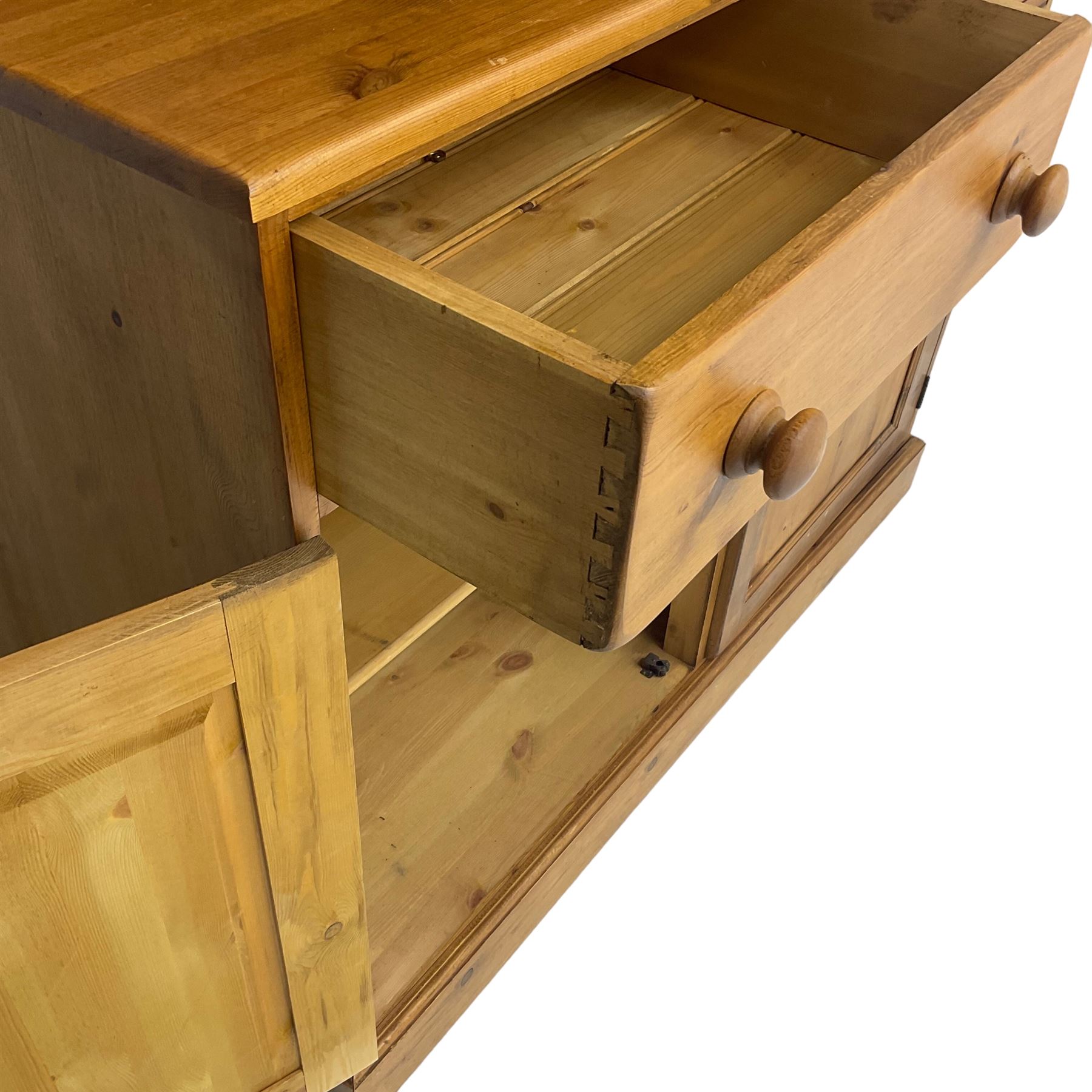 Large pine bookcase on cupboard, the upper section enclosed by two glazed door, the lower section fitted with two drawers and double cupboard, on plinth base