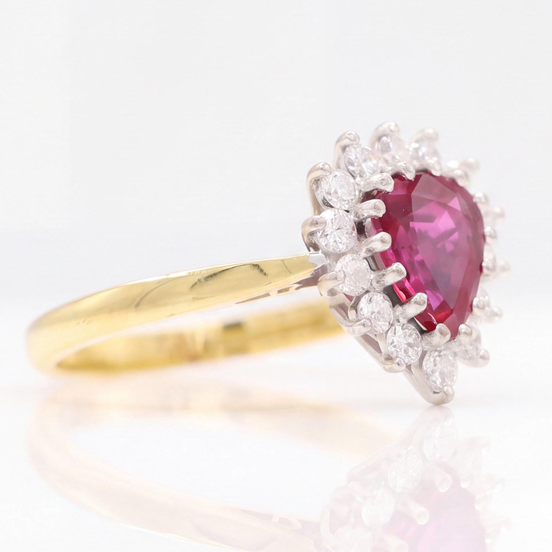 18ct gold ruby and diamond cluster ring, single pear cut ruby of approx 1.05 carat, surrounded by fourteen round brilliant cut diamonds, Birmingham 1988, total diamond weight approx 0.40 carat