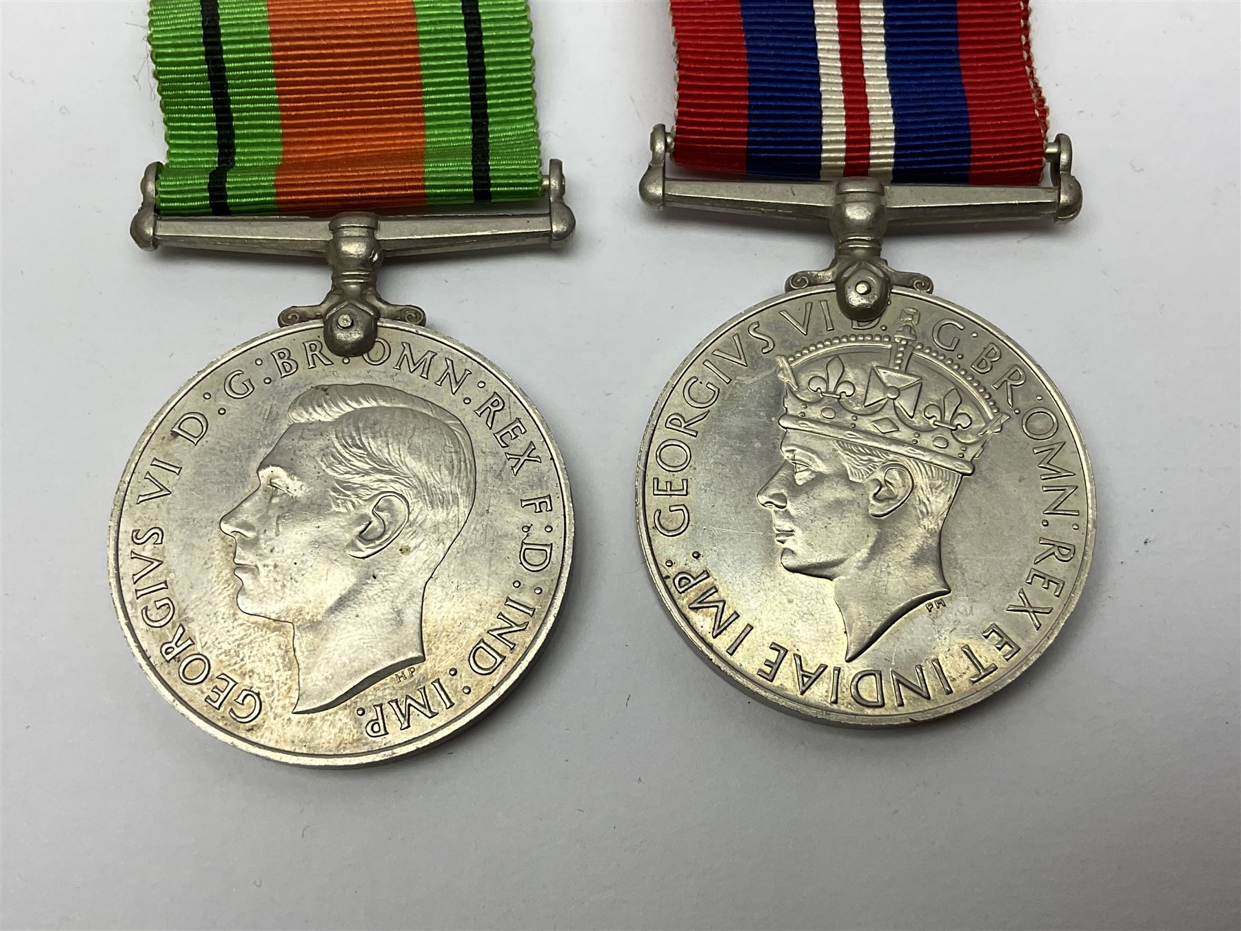 WW1 pair of medals awarded to 151761 Gnr. S. Loten R.A. with ribbons; four WW2 medals with ribbons; and small quantity of cap badges, medallions etc