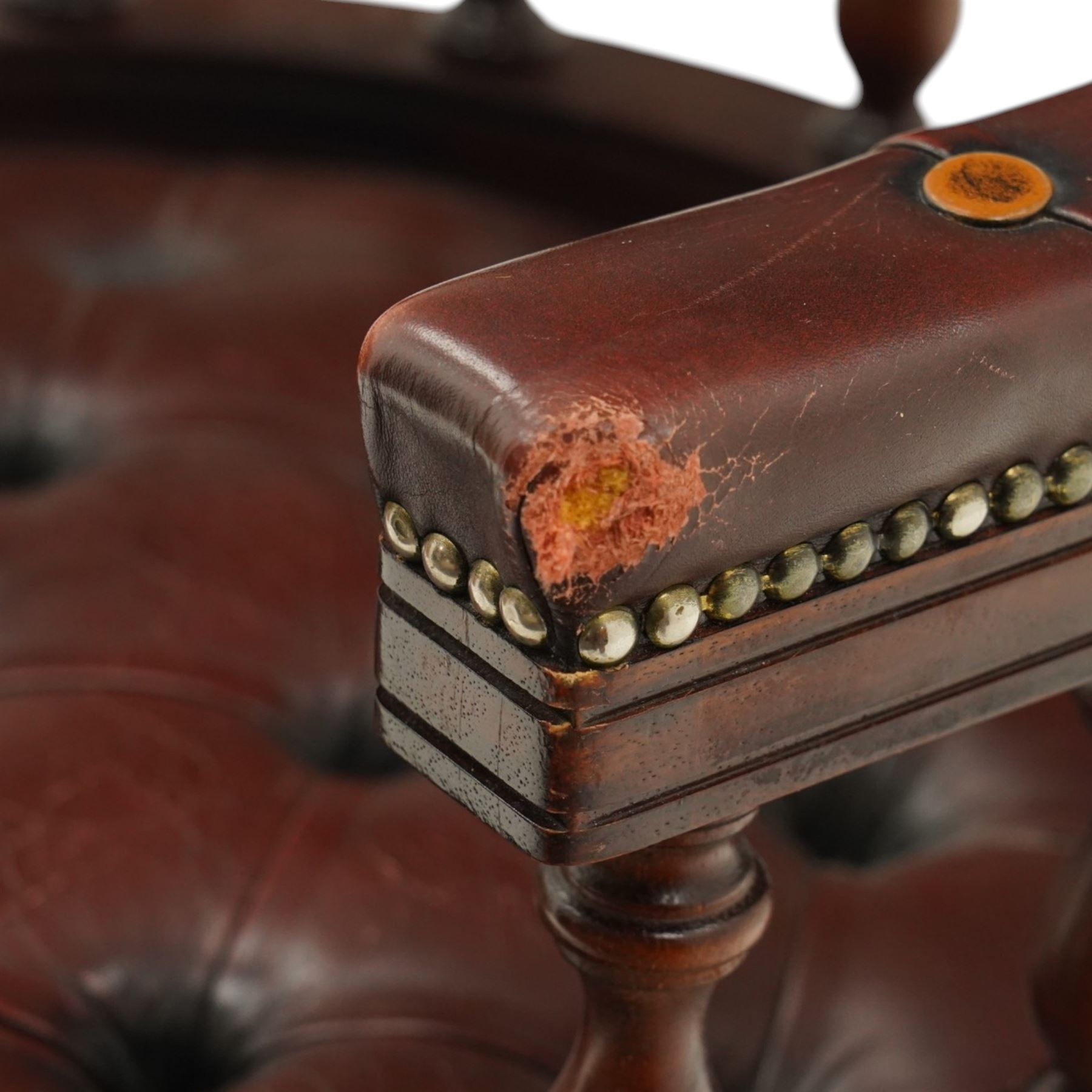 Georgian design captains swivel desk chair, rolled cresting rail over open spindle back on tripod base, upholstered in buttoned oxblood leather