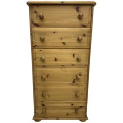 Traditional pine tall chest, fitted with six long drawers with turned handles. on compressed bun feet