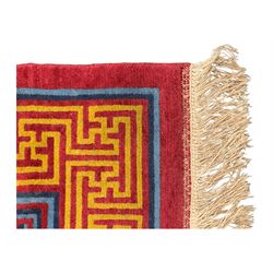Tibetan-design handwoven rug, deep red field with three central medallions in yellow and blue, traditional yellow key border, white fringes on both ends