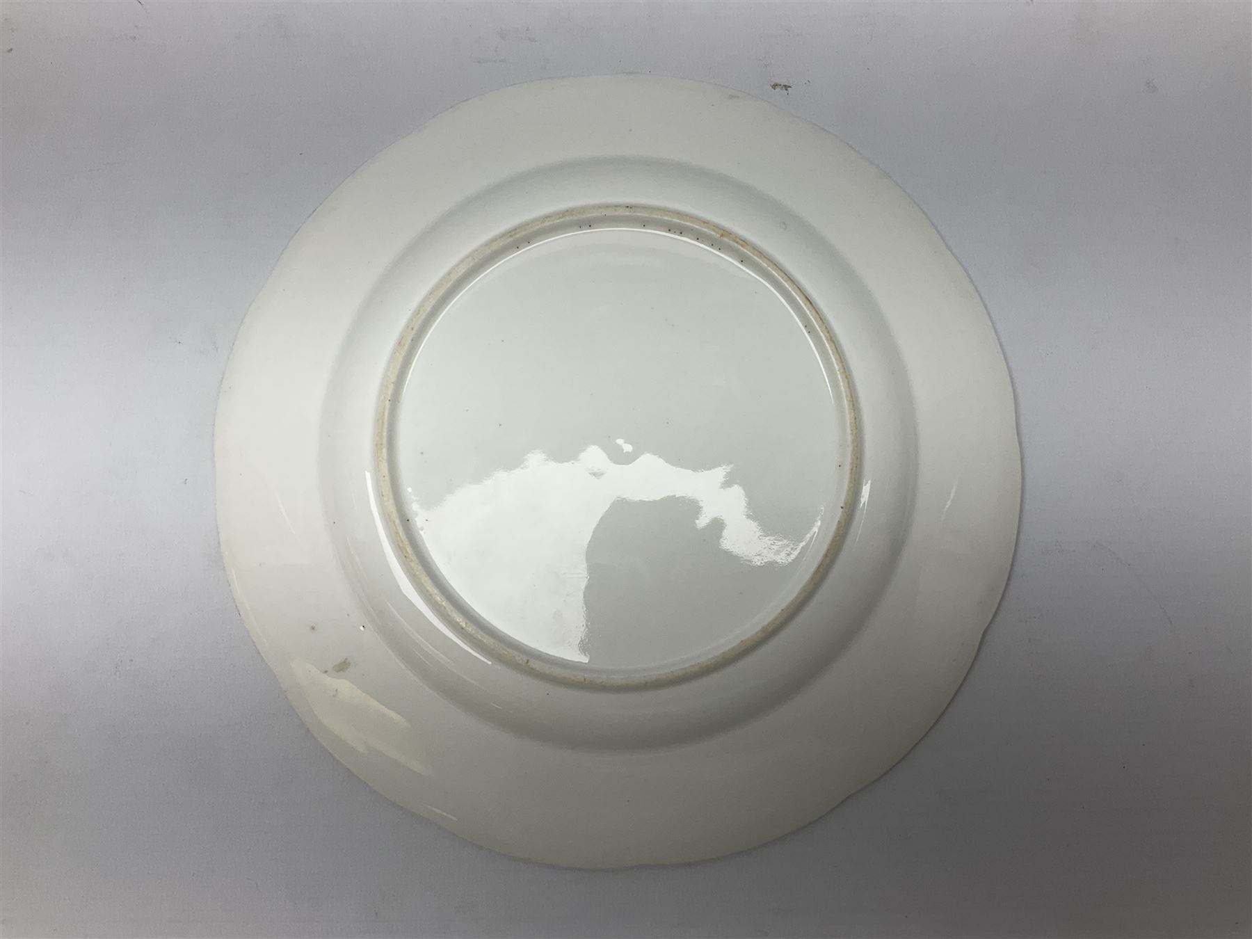 Three 19th century plates, comprising two circular examples and one oblong, each with osier moulded sides, the centres decorated in underglaze blue with Gillyflower type pattern, circular examples D25cm oblong example W27cm