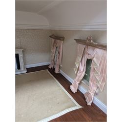 Two modern three storey dolls houses, each painted green with decorated interiors, both upon a single white wooden base, together with a large collection of dolls house furniture, accessories and figures 