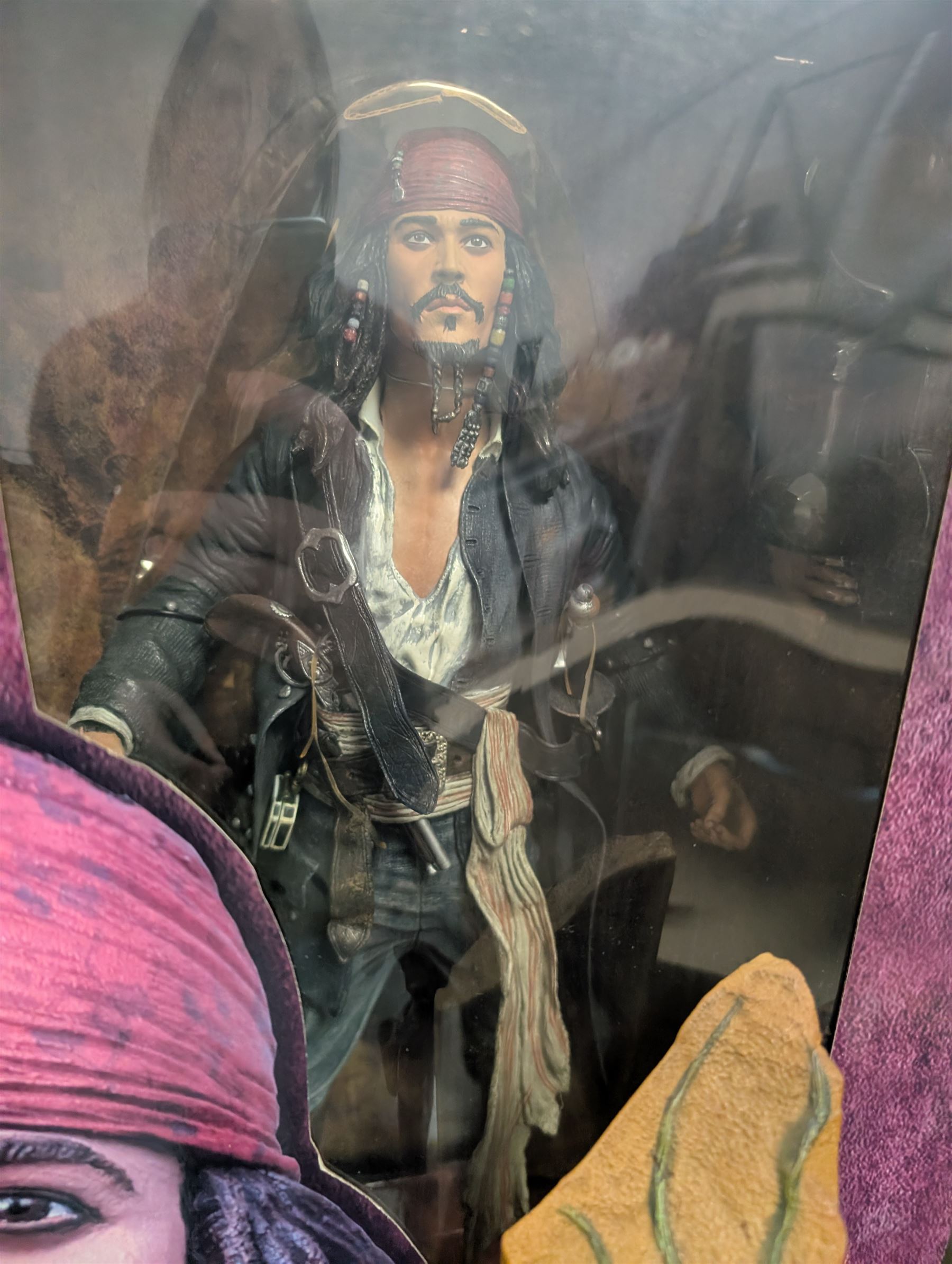 Collection of Disney and similar figures and memorabilia, including Pirates of the Caribbean Capt Jack Sparrow talking figure and NECA toys Jack Sparrow Head Knocker, three Disney showcase figures, Kermit the Frog framed film cell and Tomb Raider figure