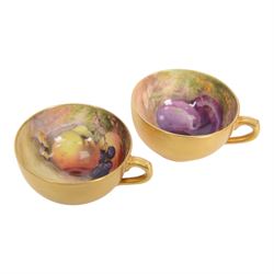 Two small 20th century Royal Worcester cabinet cups and saucers, together with another saucer, each painted with a still life of fruit upon a mossy ground, bearing various signatures: E Townsend, Ricketts, G H Cole, and H Ayrton, each with puce printed mark beneath, teacups approximately H3cm D5.5cm, coffee cup H4.5cm, saucers 9.5.cm