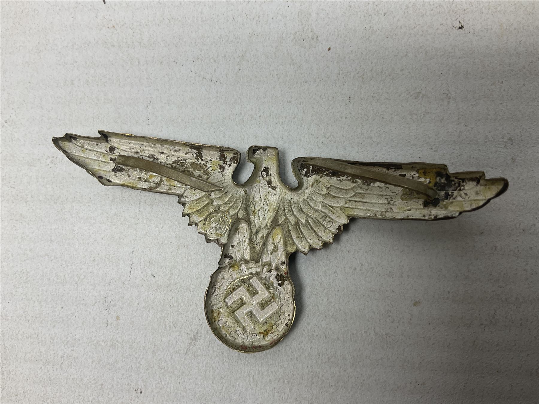 Two WW2 German 'SS' visor cap skull badges and another later; and visor cap eagle insignia (4)