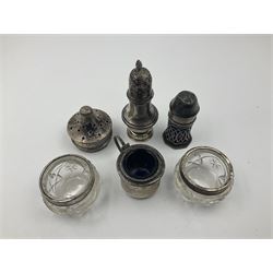 Group of silver, comprising two pepper shakers, two silver mounted glass salts, sugar caster lid and a mustard pot, all hallmarked 