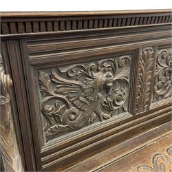 19th century oak hall bench, dentil cresting rail over moulded frame with panelled back carved with fire-breathing mythical beasts and central acanthus leaf motif, scroll carved down-sweeping arms carved with grotesque masks with scrolled foliage and shells, hinged box seat carved with scrolling foliage over panelled front with further carved foliage decoration, on paw carved front feet 