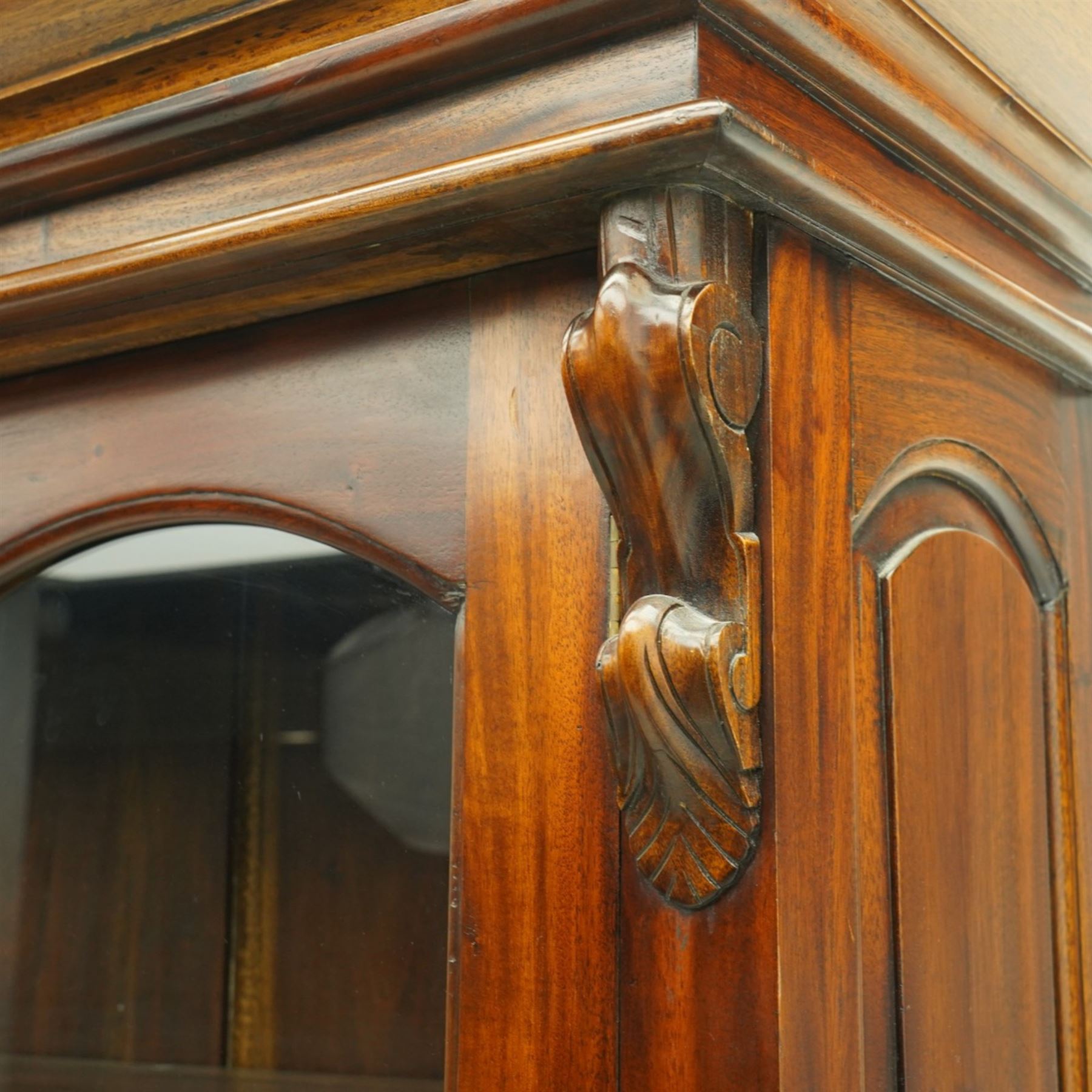 Victorian revival hardwood dresser cabinet, projecting moulded cornice above three glazed doors with shaped tops enclosing shelves, moulded top over three drawers and three panelled cupboard doors, flanked by applied carved brackets, on plinth base