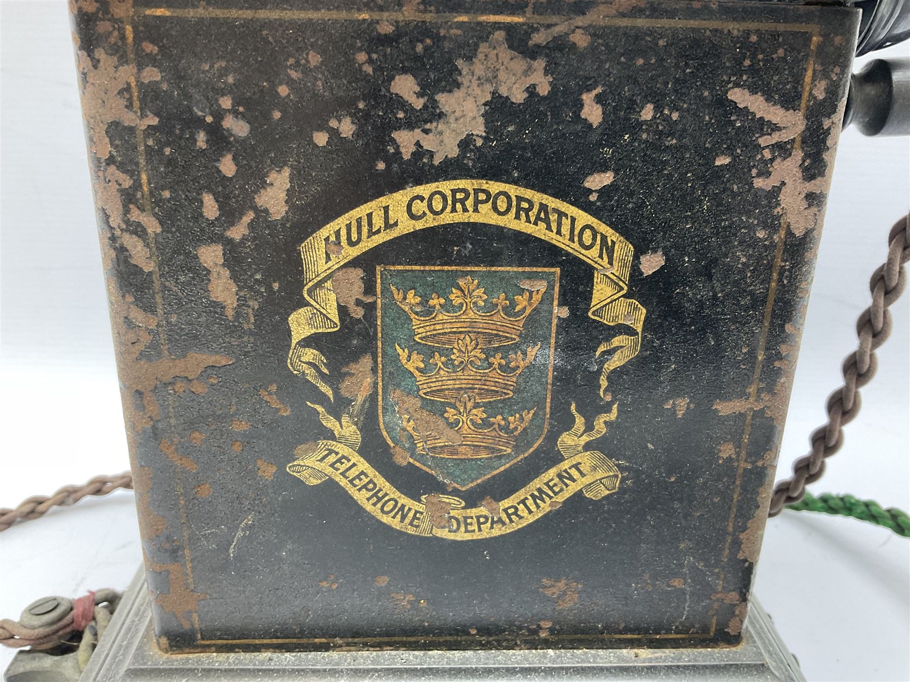Early 20th century Danish desk telephone inscribed The Ericsson Bell Telephone Co. Glasgow to one side and Aktieselskabet Electrisk Bureau Kristiansand to the other, ebonised wooden top with handset on brass cradle. black japanned tin centre section bearing Hull Corporation Telephones Department crest, side cranking handle and ebonised wooden base H30cm  