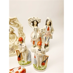 A group of various flatback figures, to include two 19th century Staffordshire flatback figures, one an arbour group, together with other later Staffordshire style examples, including a pair modelled as cow and half. (7). 

