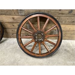 Set of four wheels from an early 20th century cart, wood with metal outer