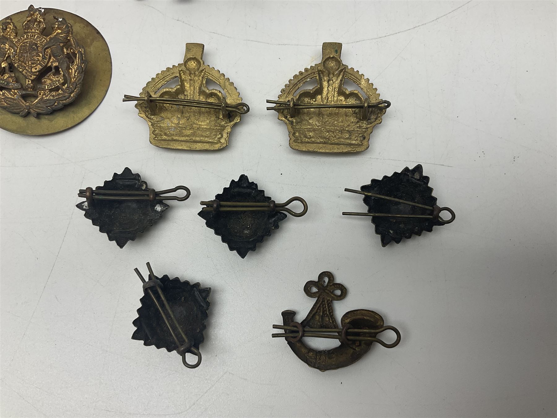 Over thirty British and Continental military metal badges; together with quantity of shoulder titles, collar dogs, rank pips, uniform buttons etc