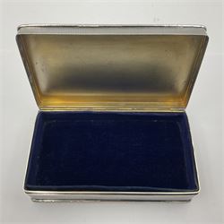 1920's silver table cigarette box, of rectangular form with engine turned decoration to the exterior, the hinged cover with central vacant rectangular panel and raised foliate rim, opening to reveal a gilt interior with later plush lining, hallmarked Charles Henry Dumenil, London 1923, H3.5cm L14.5cm D8.5cm