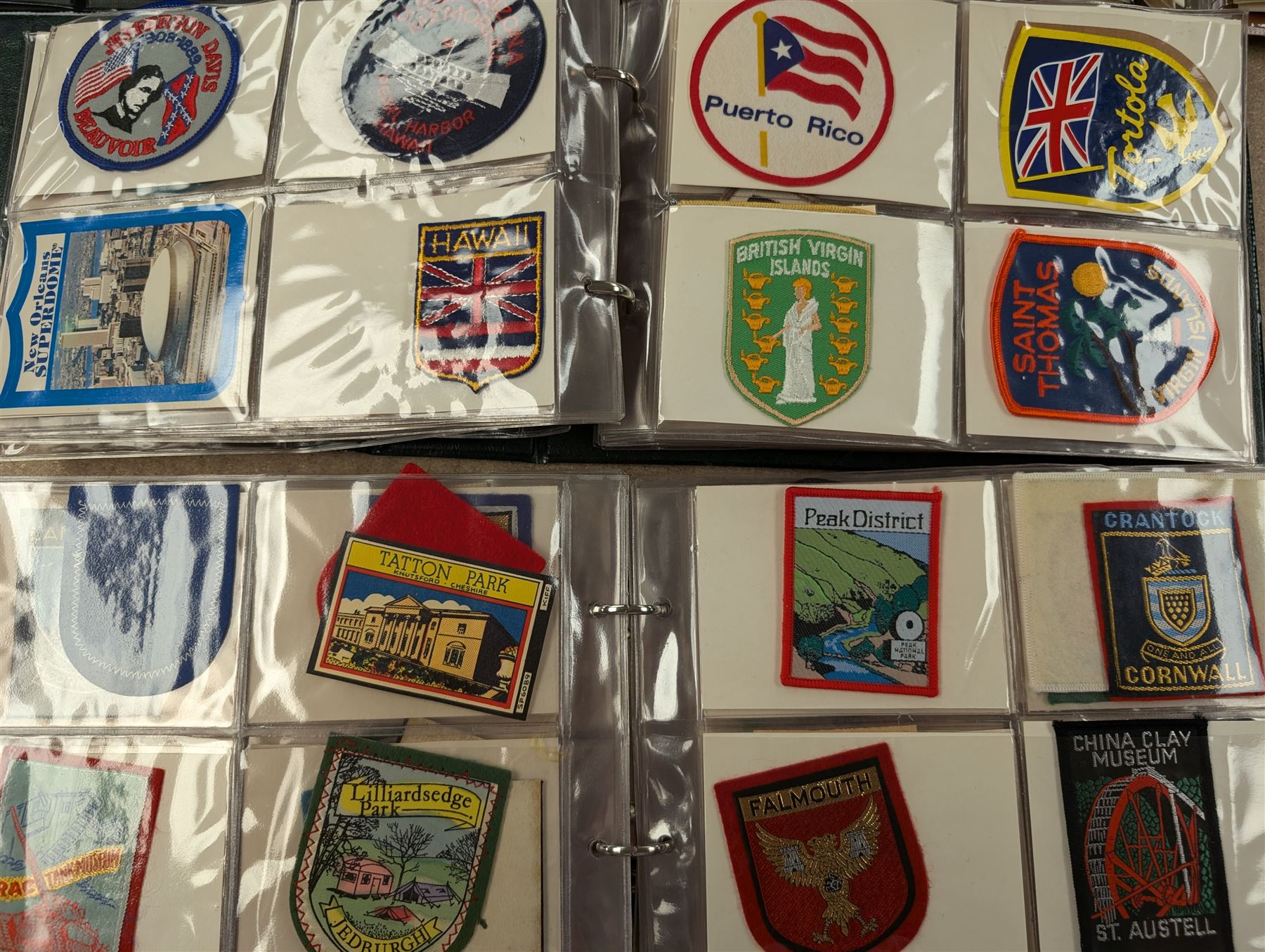 Large collection of souvenir cloth badges and vinyl stickers, mostly contained within albums