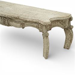 French style low console table, the shaped rectangular top with undulating outline and moulded edge, worn painted finish throughout, the frieze carved with flowing C-scrolls, shell and foliate detail centred by a floral reserve, on cabriole legs with carved knees and inward curving feet