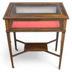 Edwardian rosewood bijouterie cabinet, the hinged rectangular top with line inlay enclosing a velvet lined interior, upon slender tapering legs inlaid with satinwood foliate marquetry decoration, with stretchers united by an under tier, raised on castors 