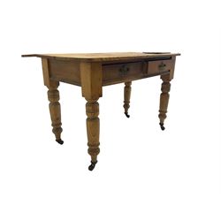 Traditional rustic pine dining table, rectangular top fitted with two drawers, raised on turned tapering supports on ceramic castors
