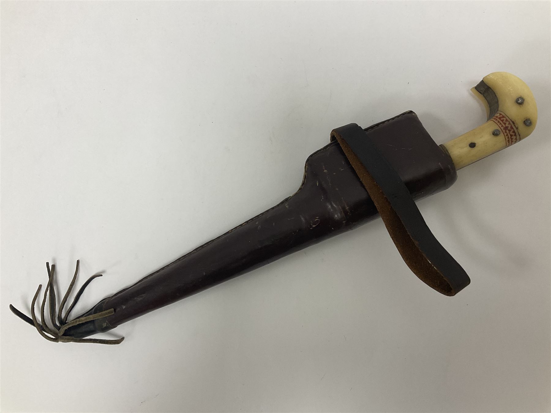 Afghan Khyber knife (Choora), blade engraved along the top edge with ornate brass and bone grip, with leather scabbard, overall L31cm, blade L20cm