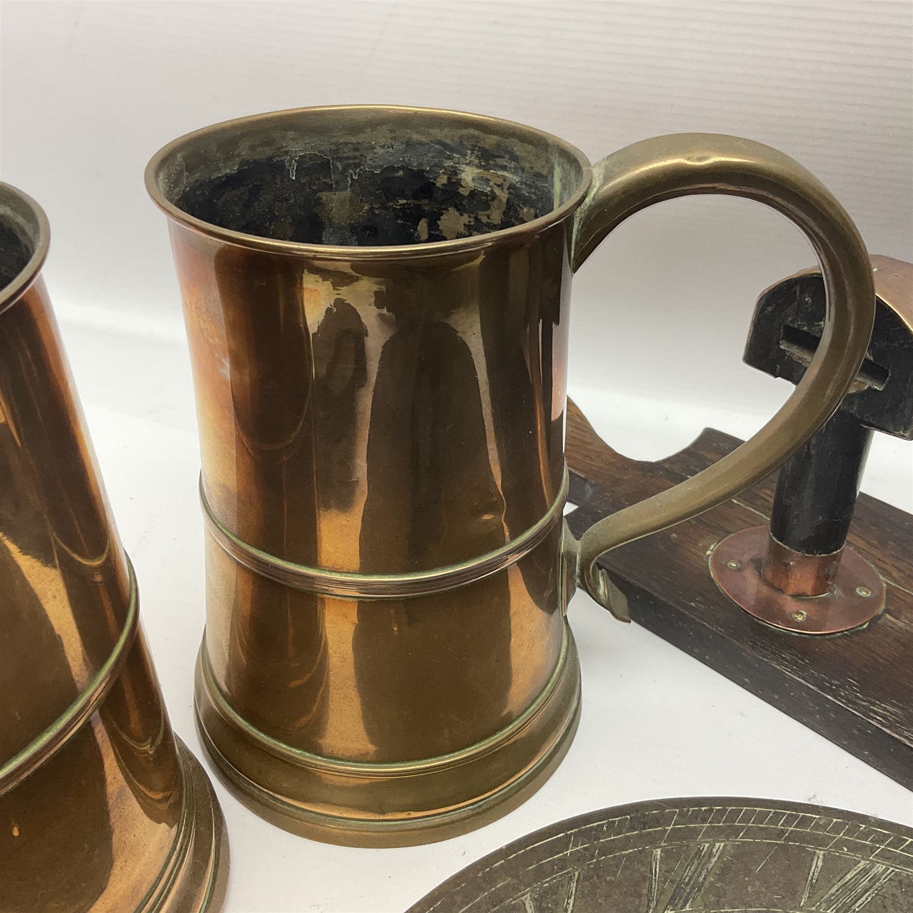 Two 19th century copper tankards, one with weighted wooden base, together with copper and wooden mechanical bellows, sundial and other metalware 