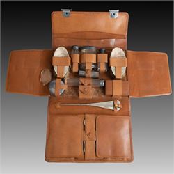 1920s gentleman's travelling case by Mappin & Webb Ltd, tan leather impressed with initials NAO, opening to reveal a compartmentalised interior containing silver mounted dressing table items, including a pair of silver mounted brushes, engraved NAO AMA 1918, hallmarked William Comyns, London 1911, five faceted glass jars and bottles with silver lids and a silver shaving brush holder, all hallmarked Mappin & Webb Ltd, London 1922, tan leather box containing razor, silver plated shoe horn, scissors and bevelled edge shaving mirror with easel support