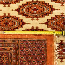 Three rugs,  comprising a Baluch rug in crimson ground, 179x97cm, a Tekke Bokhara rug in crimson ground, 201x132cm, and a Bokhara rug in ochre ground, 125x175cm 